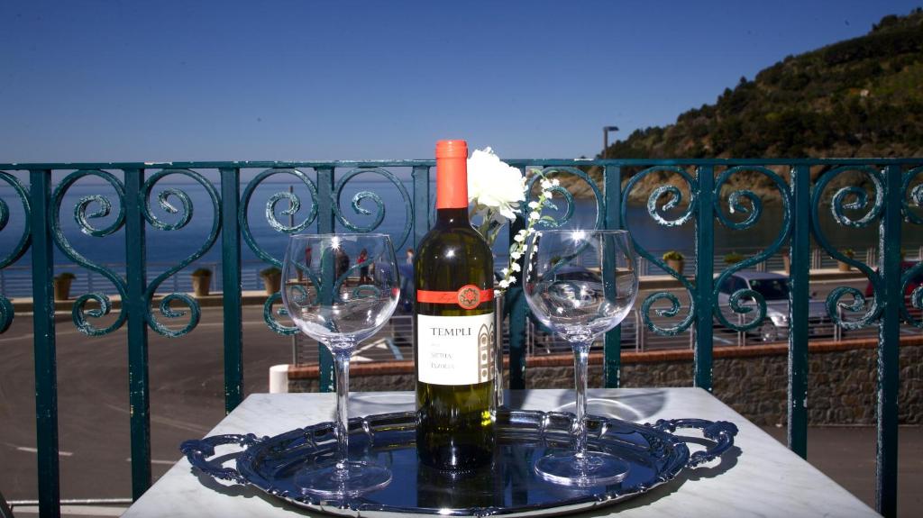 ボナッソーラにあるHotel Felucaのワイングラス2杯付きのテーブルに置かれたワイン1本