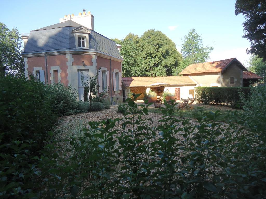 an old house with a garden in front of it at La Maison des tilleuls in Entrains-sur-Nohain
