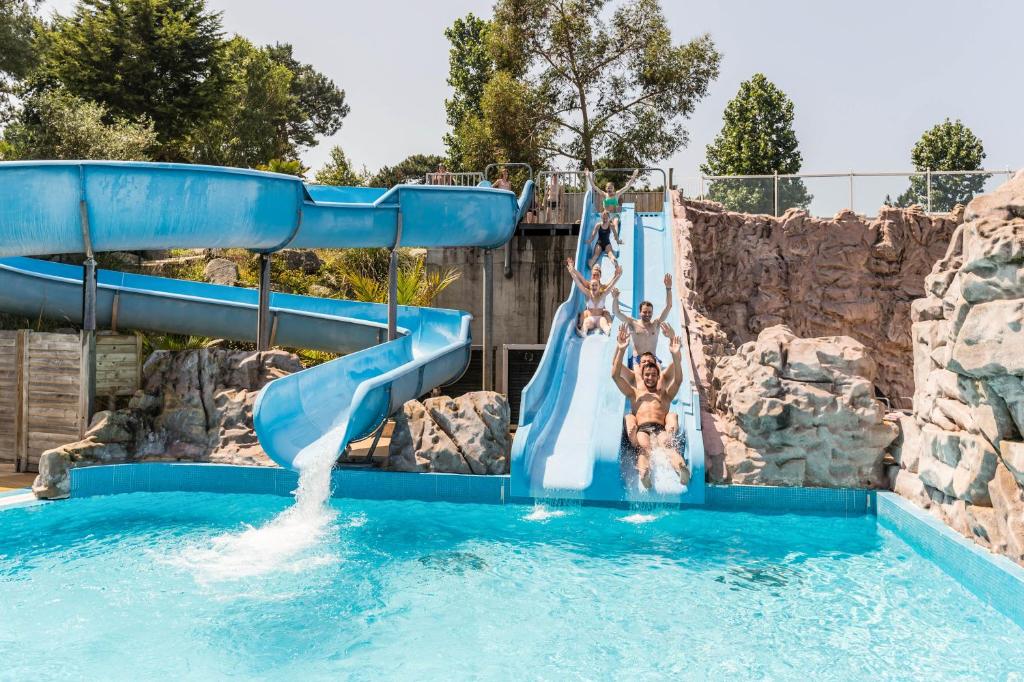 a group of people on a water slide in a pool at Mobil Home XXL 4 chambres - Camping Les Pins in Erquy