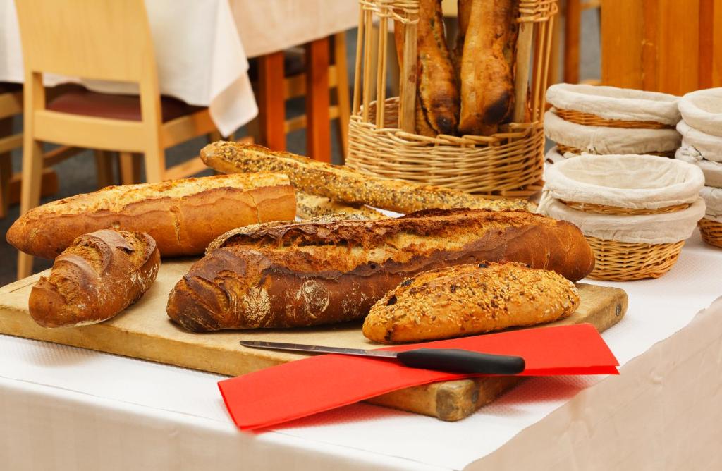 a table topped with bread and pastries on a table at Hôtel Eliova Le Chaix in L'Alpe-d'Huez