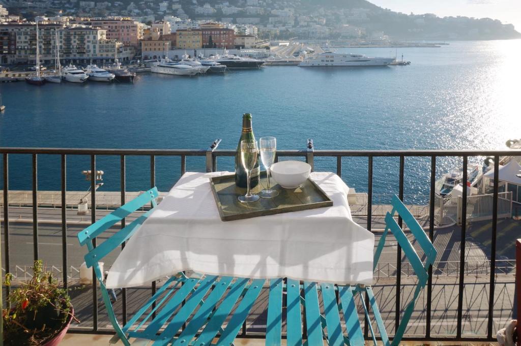 - une table avec une bouteille de vin et des verres sur un balcon dans l'établissement Waterfront panoramic sea view, balcony, AC, à Nice