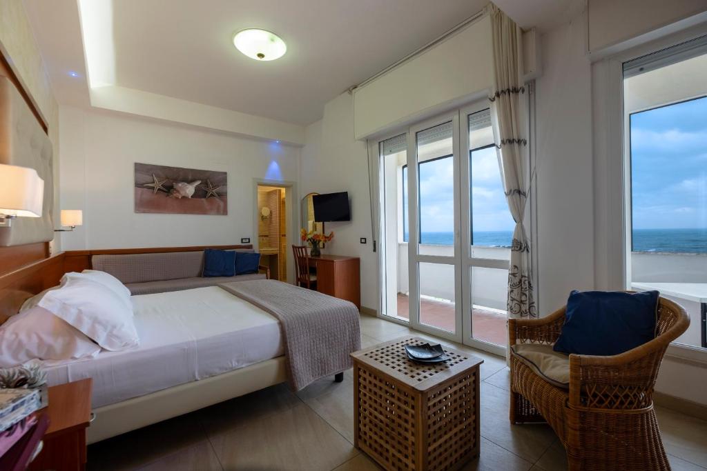 a bedroom with a bed and a balcony with the ocean at Hotel Elios in Bellaria-Igea Marina