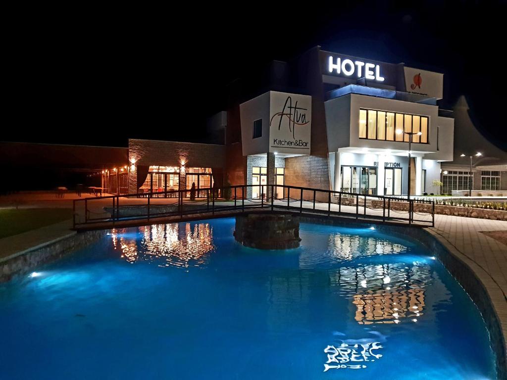 a large pool in front of a hotel at night at Atva Residence Hotel in Dolni Dobrenoec