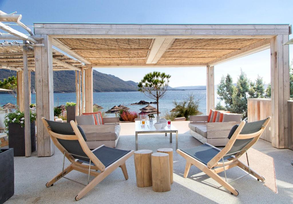 a patio with chairs and a table and a couch at La Plage Casadelmar in Porto-Vecchio
