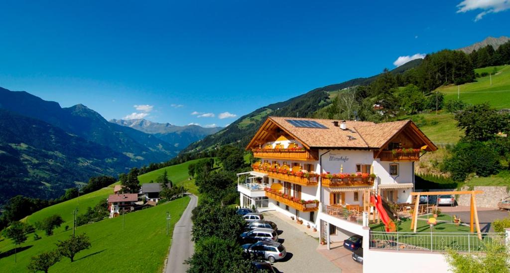 a large building with cars parked in front of it at Pension-Appartement Mitterhofer in Schenna