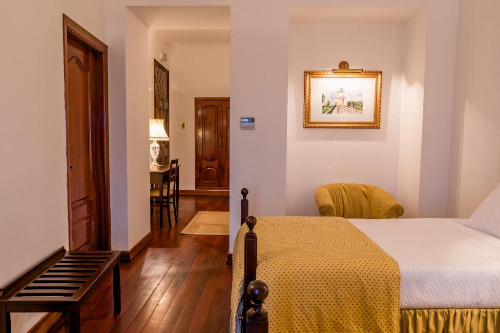 um quarto com uma cama, uma mesa e uma cadeira em Casa Amarela TH & National Monument em Castelo de Vide