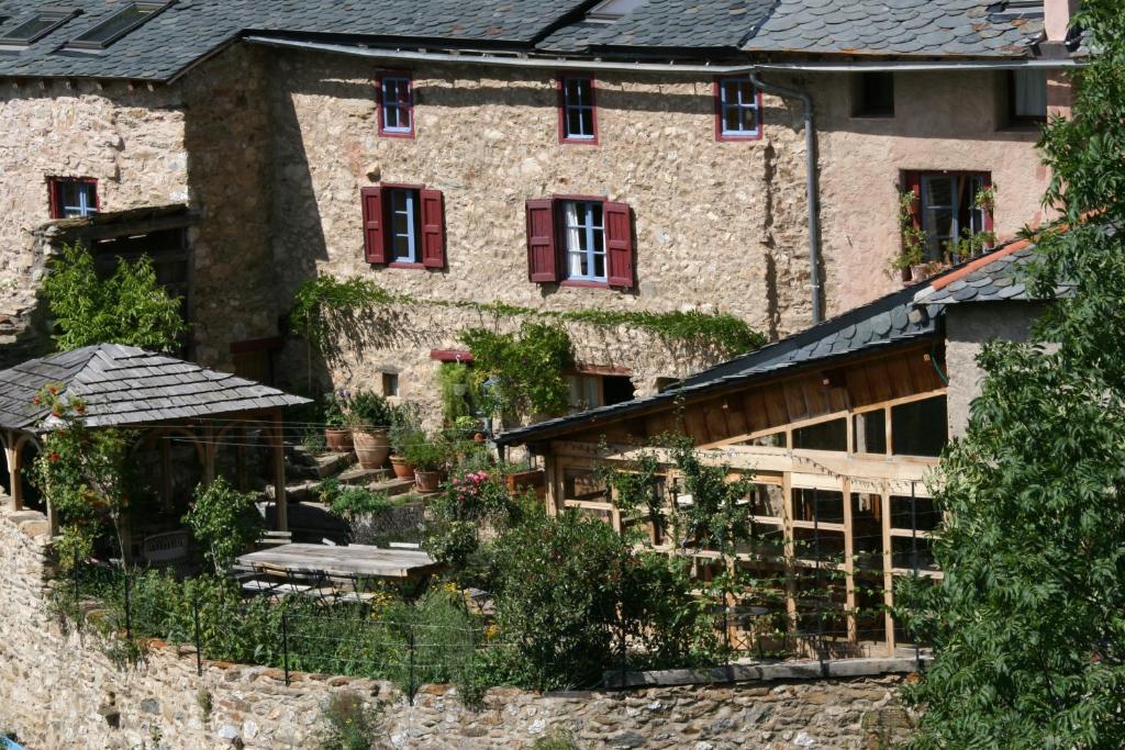 un antiguo edificio de piedra con un jardín delante de él en Chambres d'Hôtes Cal Miquel, en Llo