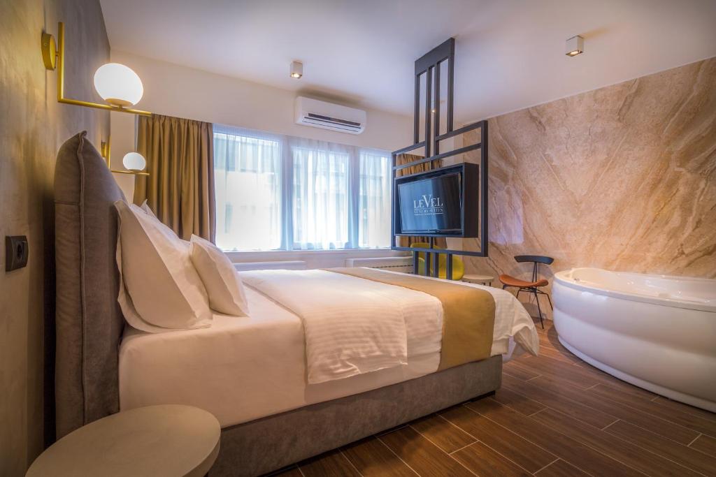 a hotel room with a bed and a bath tub at Level Luxury Suites in Belgrade