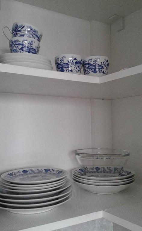 a kitchen with blue and white plates and bowls on shelves at Mountain View Studio Apartment in Poprad