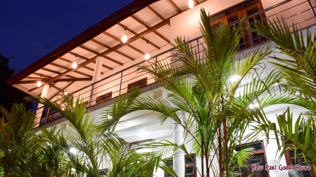 un edificio con palmeras delante en New Rasi Guest House, en Dambulla