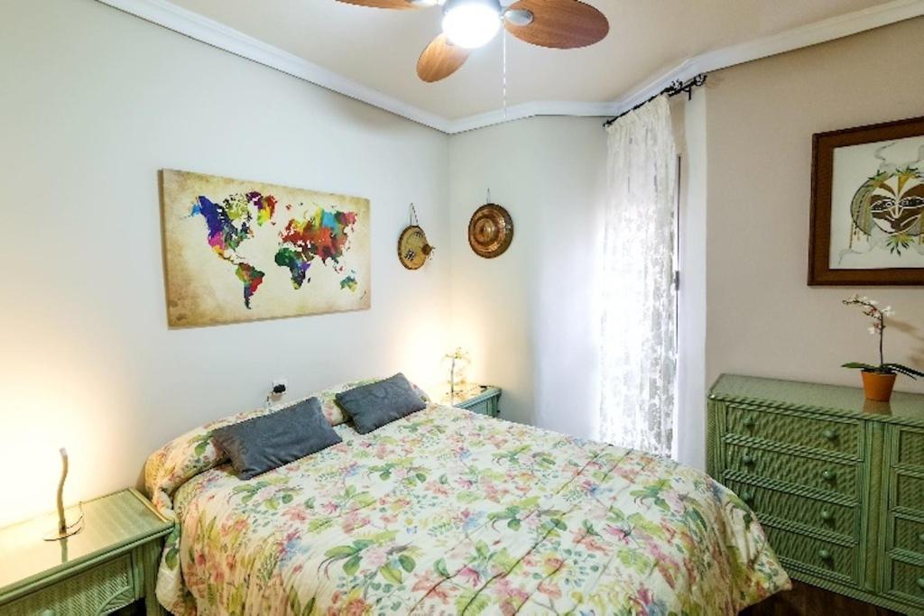 une chambre avec un lit et un ventilateur de plafond dans l'établissement Apartamento Azahara, à Cordoue