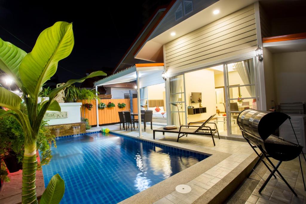 una piscina frente a una casa por la noche en Pattaya Pool Villa 39B 300 mater to beach gate en Pattaya South
