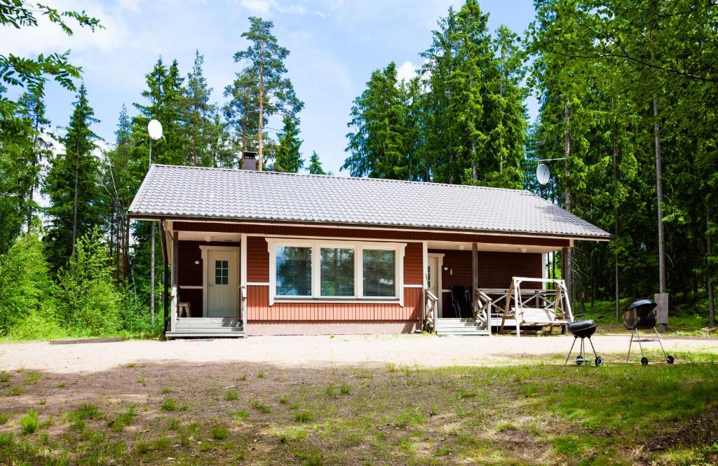 uma pequena casa no meio de um quintal em Niemenkärki em Kouvola