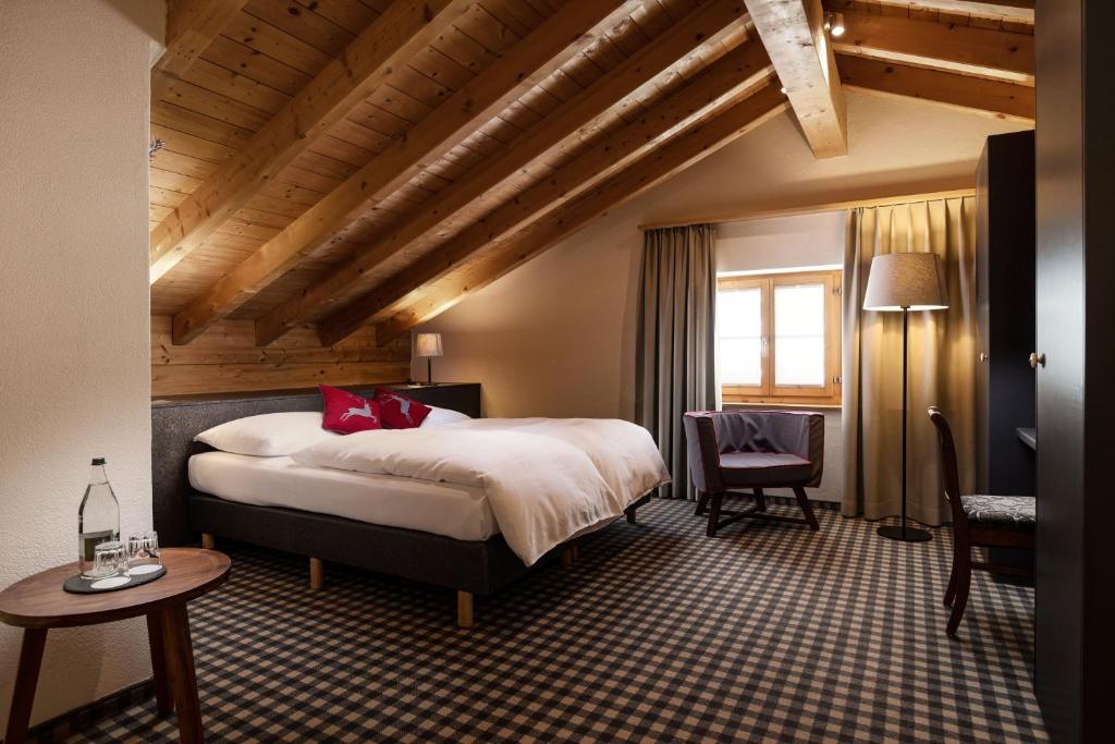 a hotel room with a bed and a table and chairs at 7132 Glenner in Vals