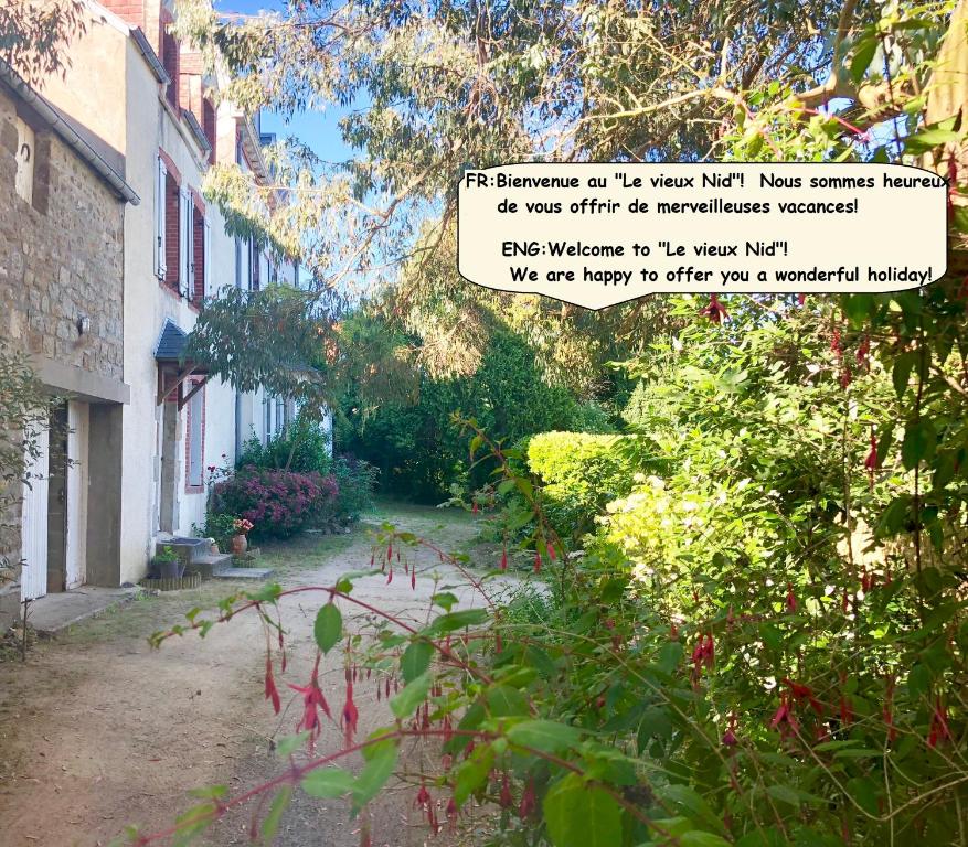 a sign in a garden next to a building at "Le Vieux Nid" in Carolles