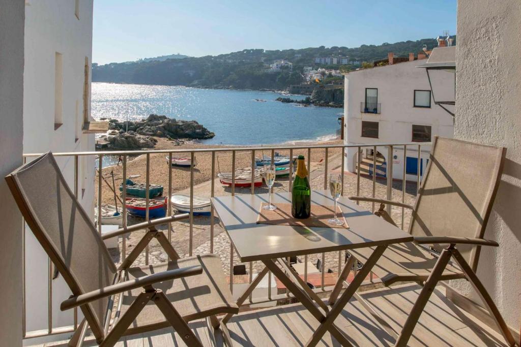 una mesa y sillas en un balcón con vistas al océano en Apartament Cortey en Calella de Palafrugell