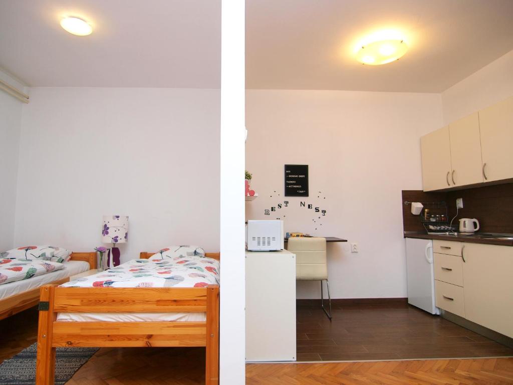 a kitchen and a bedroom with a bed and a kitchenette at Studio apartman Rest Nest in Čakovec
