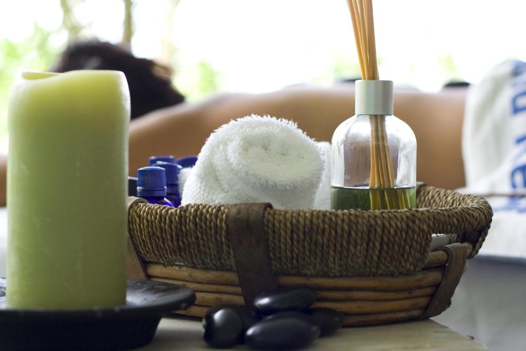 a basket with towels and a candle on a table at Young Island Resort in Kingstown