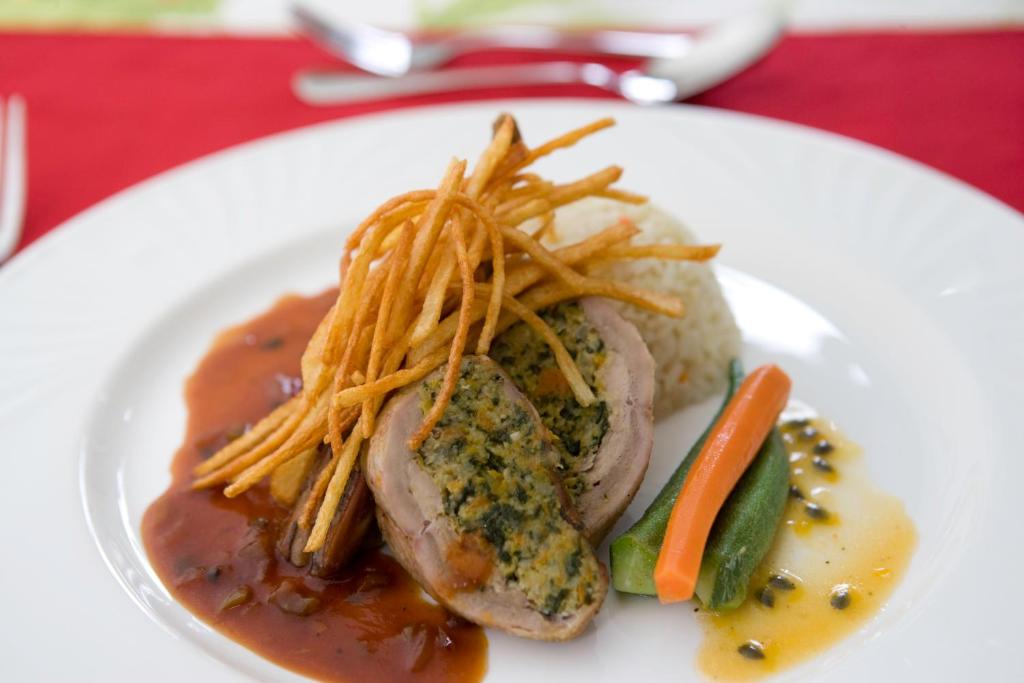 a plate of food with meat and fries and vegetables at Young Island Resort in Kingstown