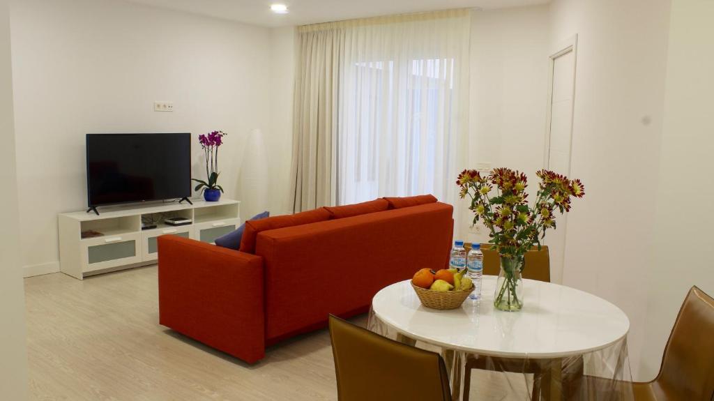 - un salon avec un canapé rouge et une table dans l'établissement Piso Lagunero Acogedor, à La Laguna