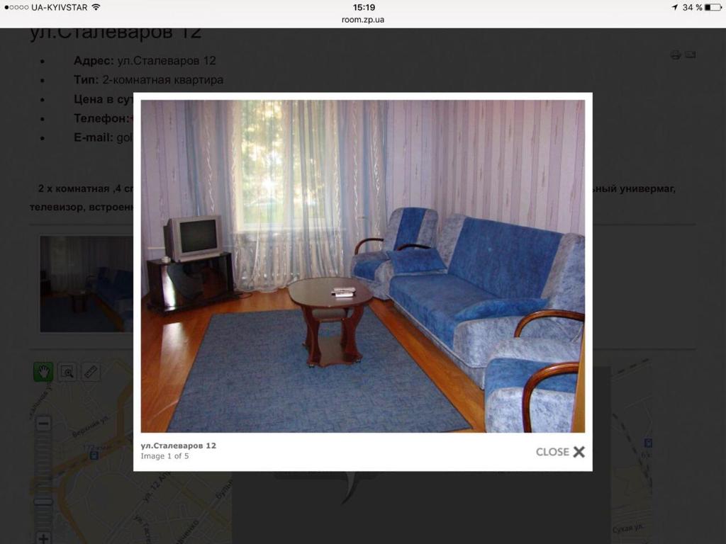 ザポリージャにあるApartments on Stalevariv 12のリビングルーム(青いソファ、テーブル付)
