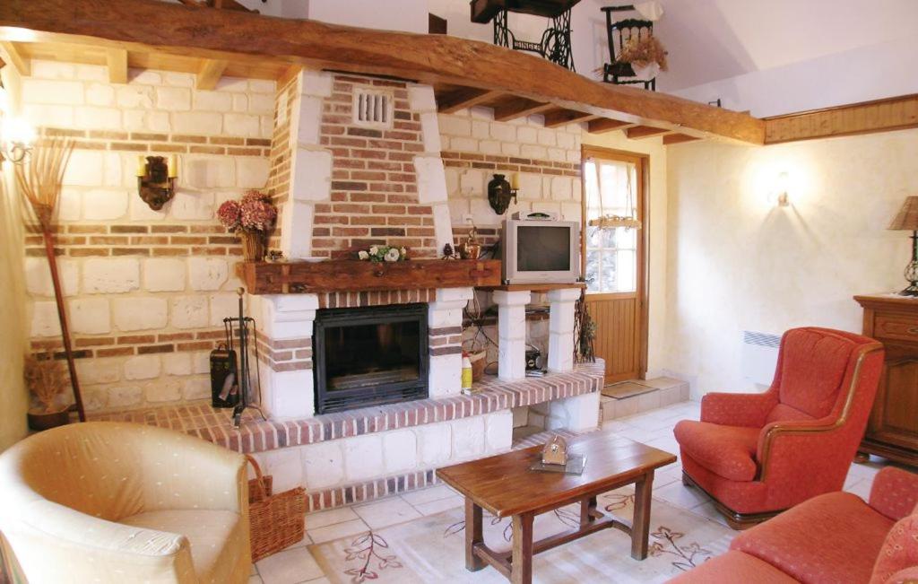 a living room with a fireplace and a tv at la roseraie in Caumont