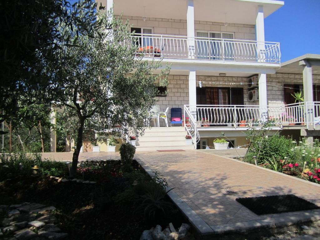 a large white house with a tree in front of it at Apartments Biočić in Korčula