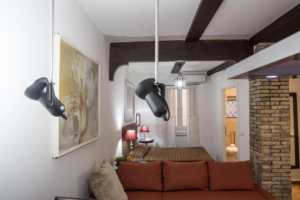 a living room with a couch and a brick wall at Campo de' Fiori apartment in Rome