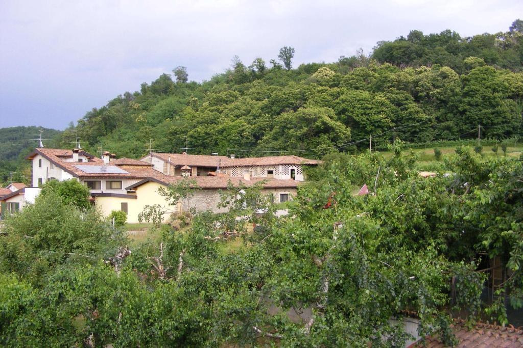 dom na zboczu wzgórza z drzewami w obiekcie Agriturismo Cascina Rossano w mieście Provaglio d'Iseo