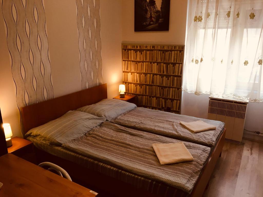 a bedroom with a bed with two towels on it at Stella Vendégház in Debrecen