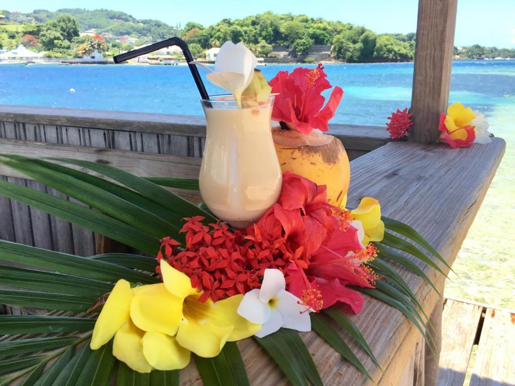 a bouquet of flowers and a drink on a table at Young Island Resort in Kingstown