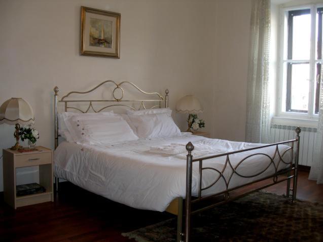 a bedroom with a white bed and a window at AL PONTEROSSO in Trieste