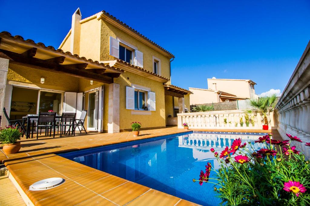 a villa with a swimming pool in front of a house at Villa del Mar in Capdepera