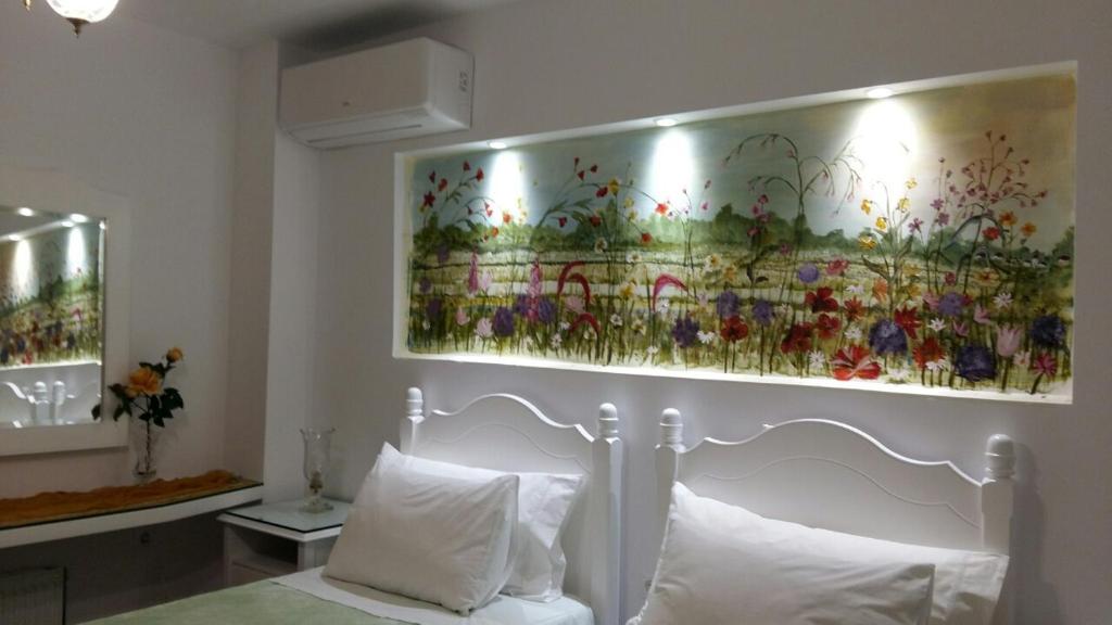 um quarto com uma pintura de flores por cima de uma cama em NN Luxury Room near Athens Airport em Spata