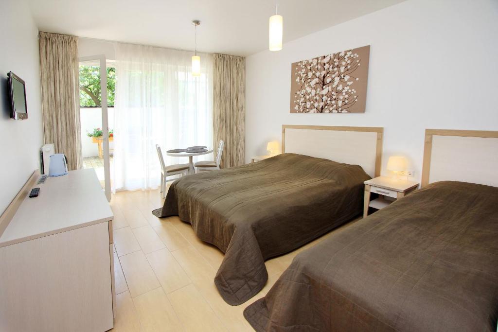 Habitación de hotel con 2 camas y mesa en Vila Domino, en Palanga