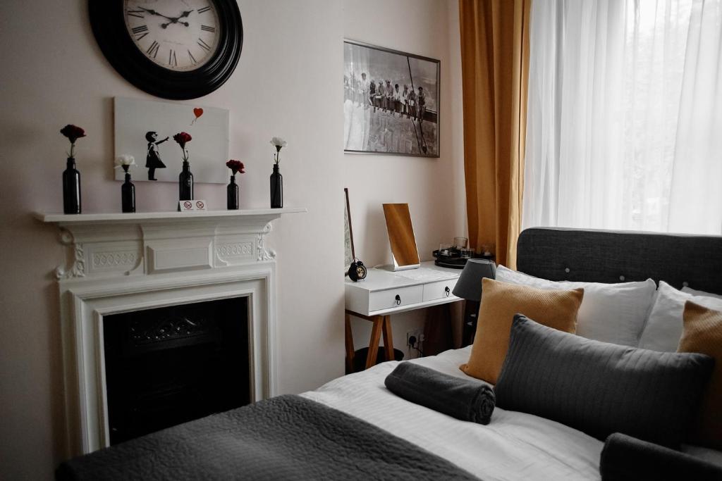 a bedroom with a fireplace and a clock on the wall at Central Located One Bedroom Apt in Bristol