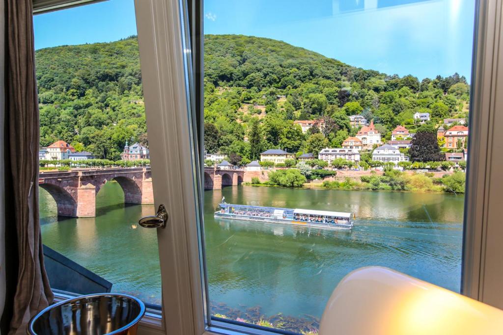 einen Blick aus einem Fenster auf einen Fluss mit einer Brücke in der Unterkunft BS Luxury Suites in Heidelberg