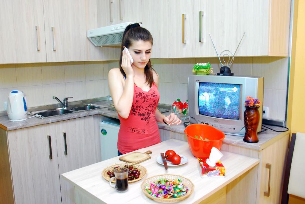 Una mujer en una cocina hablando por celular en Armenia Hostel, en Ereván
