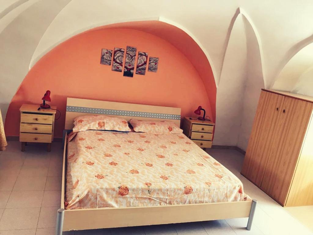 een slaapkamer met een bed met een oranje muur bij Casa vacanze Arimondi in Porto Cesareo