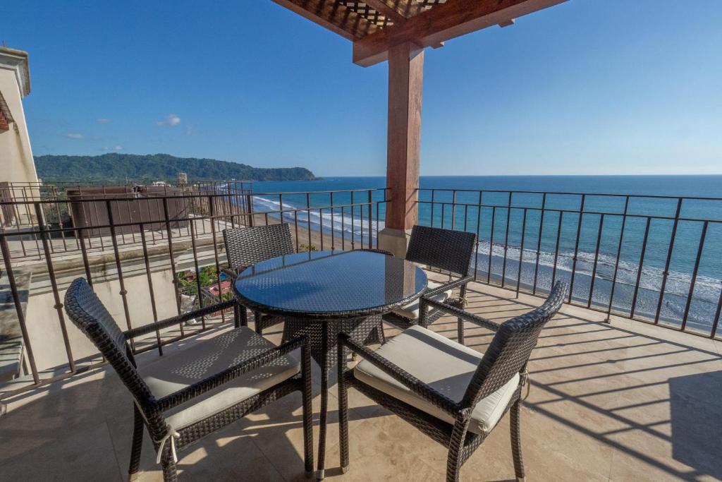 a table and chairs on a balcony overlooking the ocean at Expectacular Penthouse frente al Mar con Jacuzzi in Jacó