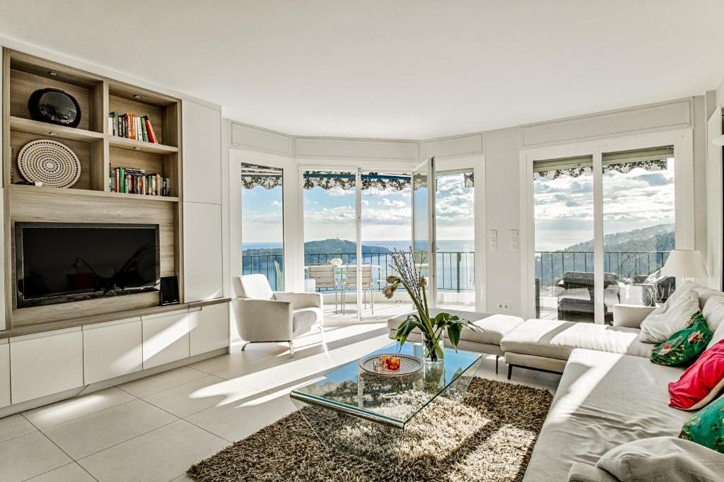 ein Wohnzimmer mit einem Sofa und einem TV in der Unterkunft Luxurious Penthouse with panoramic view in Villefranche-sur-Mer
