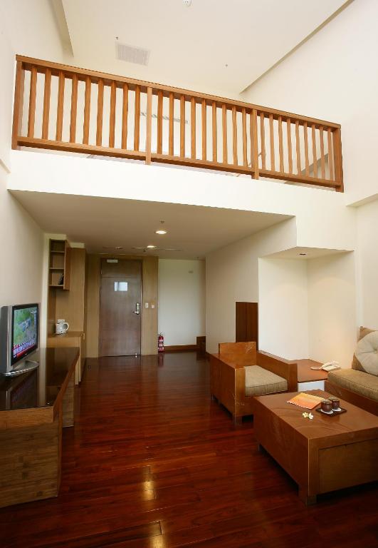 a living room with a staircase and a couch at Luminous Hot Spring Resort &amp; SPA in Luye