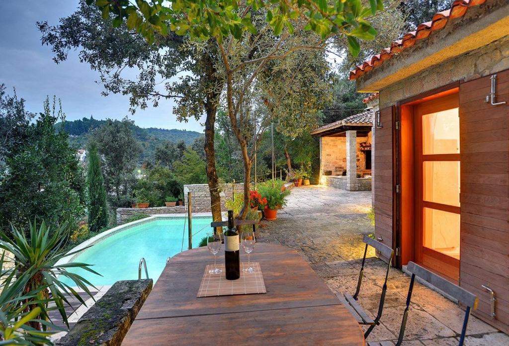 a table with a bottle of wine next to a pool at Villa Mala Villa in Krnica
