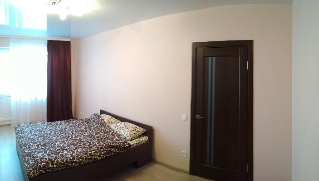 Schlafzimmer mit einem Bett und einer schwarzen Tür in der Unterkunft Comfortable apartments in Riwne