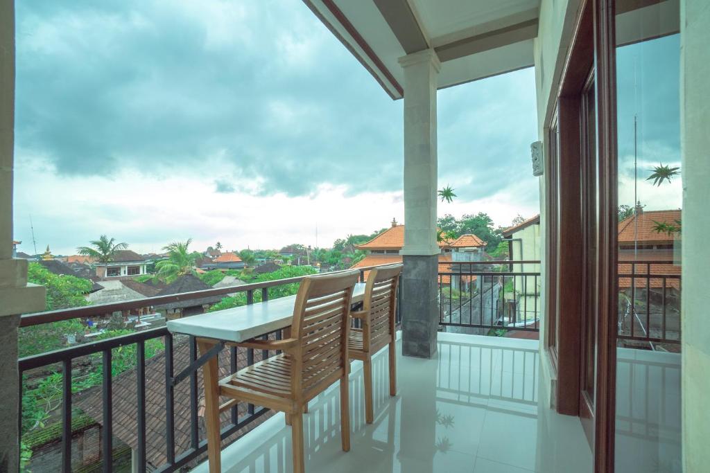 einen Balkon mit einem Tisch und Stühlen sowie Aussicht in der Unterkunft Japa House in Ubud