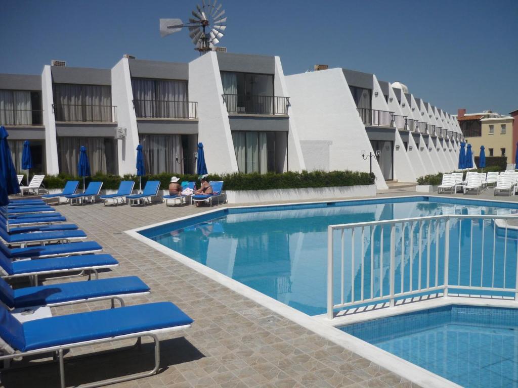 a hotel with a swimming pool and lounge chairs at Penelope Beach Hotel Apts in Protaras