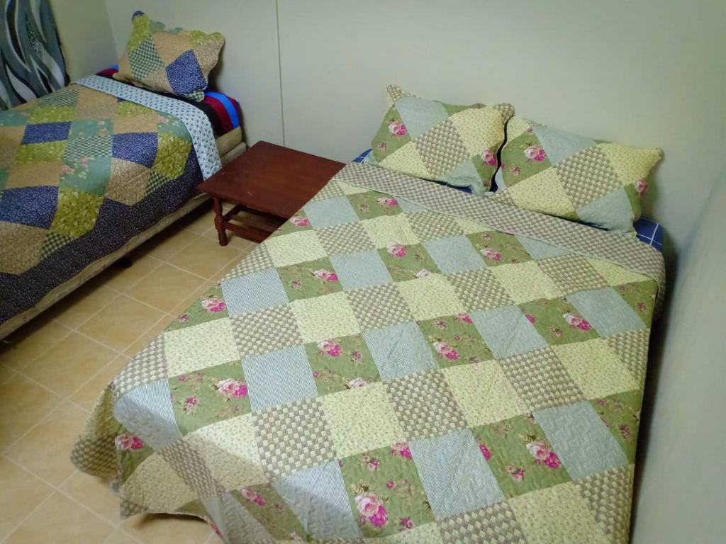 a bedroom with a bed with a quilt on it at Homestay Sejati in Kuala Berang