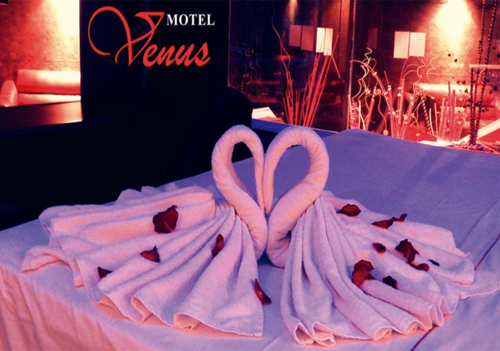 Auto Hotel Venus في خالابا: منشفتان على شكل قلوب فوق طاولة