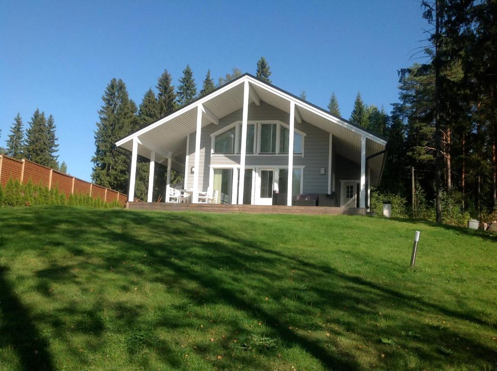 Rääkkylä的住宿－Villa koivula，前面有草坪的白色房子