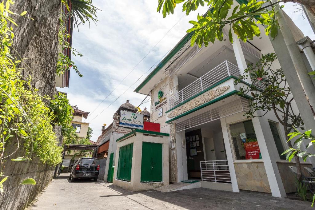 un edificio con una puerta verde en una calle en Ara Inn Bed And Breakfast by ecommerceloka, en Kuta